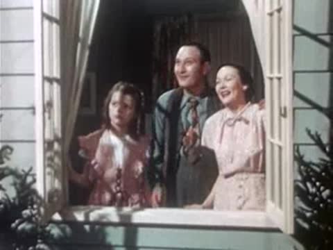 A family looks out a window with natural light streaming into the room.