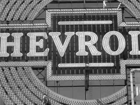 Close-up pan across the illuminated letters of the Chevrolet sign.