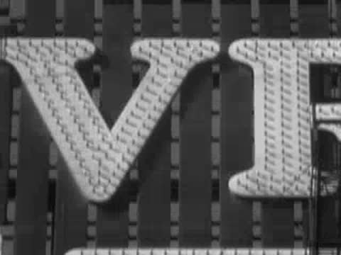 Close-up of the giant illuminated lettering reading VIVU on a sign.