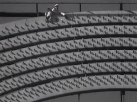 Worker walking along the curved architectural details of a sign.