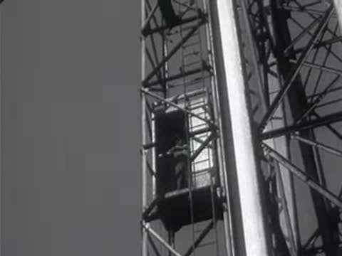 An elevator ascending the framework of a large outdoor sign.
