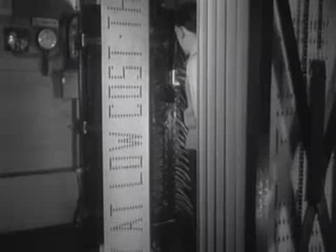 Close-up of a worker operating light switches for a large vertical sign.
