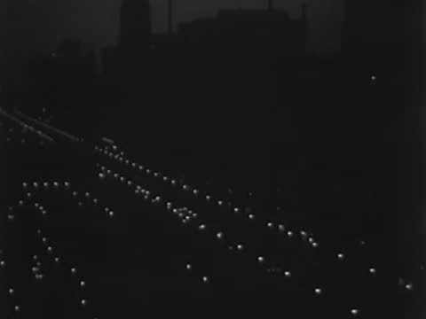 Wide shot of the city skyline at night with a Chevrolet sign and end title.