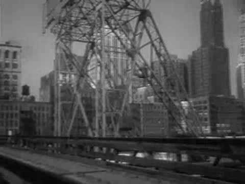 Panning shot across a large bridge structure towards city buildings.