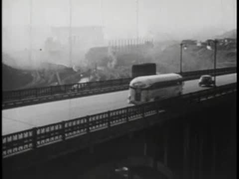 Bus crossing bridge on highway, vintage traffic, 1940s era.