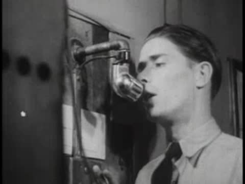Close-up of a terminal staff member speaking into an old telephone mouthpiece