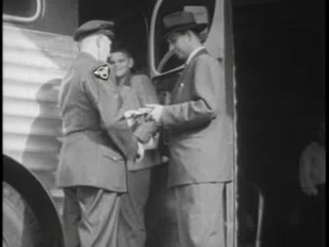 Boy handing his ticket to the driver at the bus door before boarding