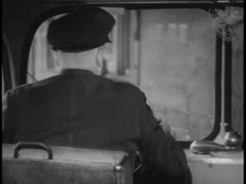 Driver sitting at the steering wheel of the bus looking forward out the window
