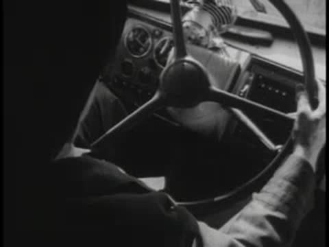 View of the driver's hands holding the large steering wheel of a moving bus
