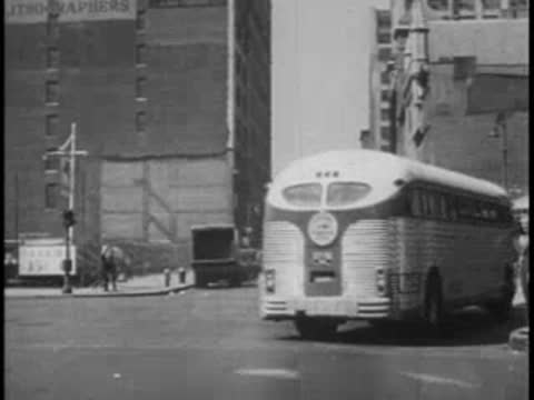 Rear view of a vintage intercity bus driving down a city street.