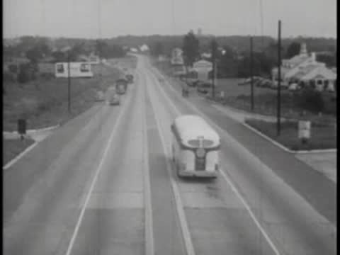 View from a bus driving down a multi-lane highway in the countryside.
