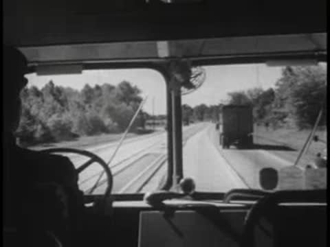 Driver's view from inside a bus passing a truck on a highway.