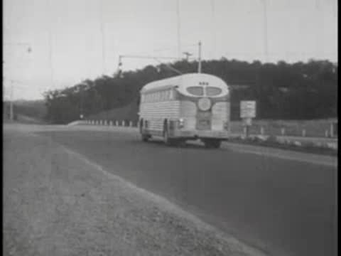 Rear view of a vintage bus traveling on a winding country road.
