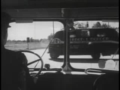 Driver's view from a bus passing cars on a two-lane country road.