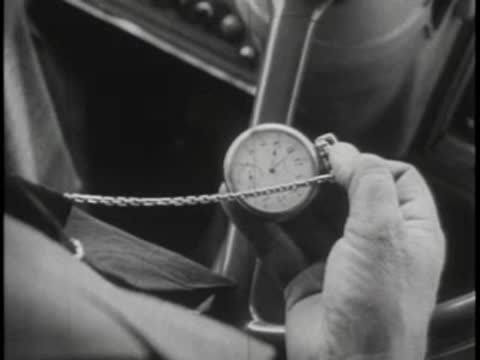 Close-up of a bus driver's hands holding a vintage pocket watch on a chain.