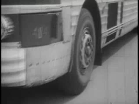 Close-up of the front wheel and side of a moving bus.