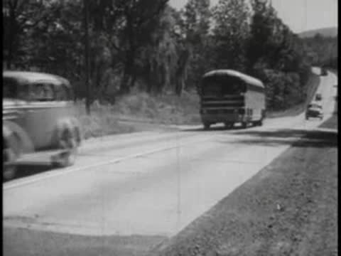 A car passes a bus and a truck on a highway.