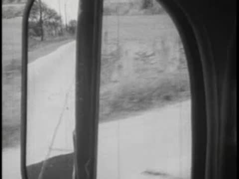 View from a bus window passing another vehicle on a rural road.