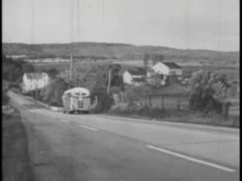 Bus passing camera on road, countryside landscape, vintage film.