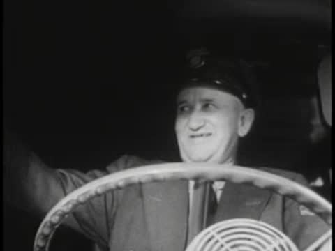 Bus driver smiling and waving while driving, uniform, hat.