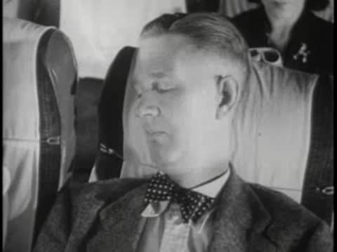 Male passenger sleeping in bus seat, bow tie, travel.