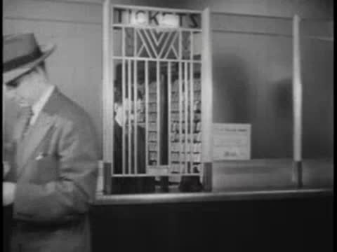 A young boy receives a ticket at the window, cut to bus outside