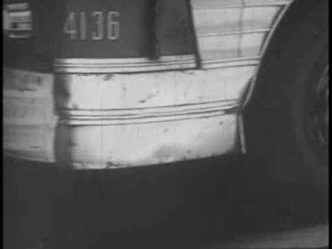Close-up of the lower side of a parked bus showing rear wheel and body panel