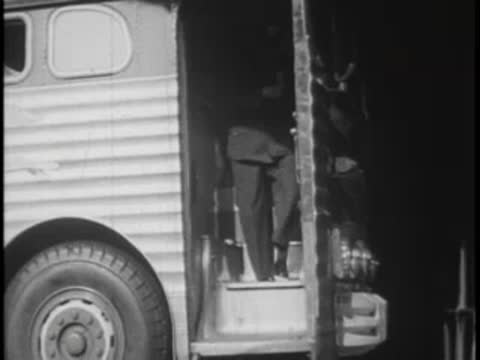Driver walking out of a parked bus doorway onto the pavement
