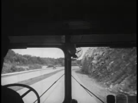 Driver's view approaching a rock cut section of a multi-lane highway.