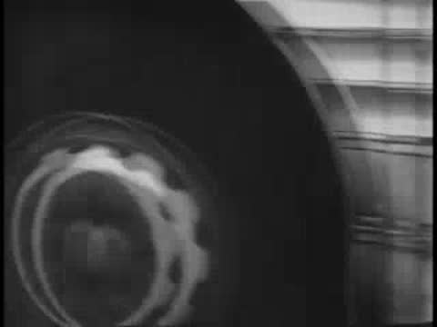 Extreme close-up panning across the lower body panels and wheel of a bus.