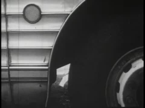 Close-up of a bus wheel well and side panel with round window port.