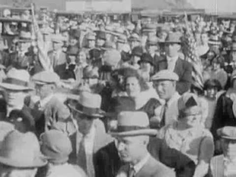 Large crowd of people outdoors with hats and winter coats.