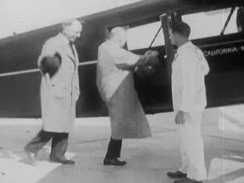Men board a small passenger airplane on an airfield.