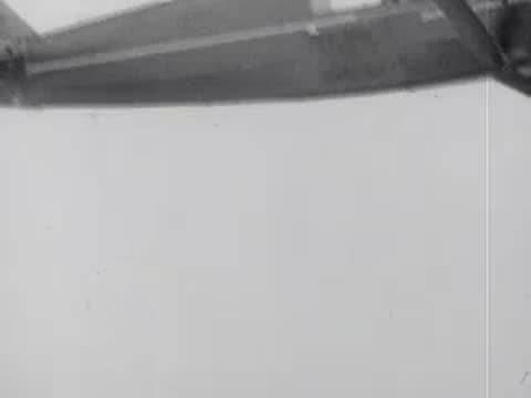 A vintage high-wing airplane in flight viewed from the side.