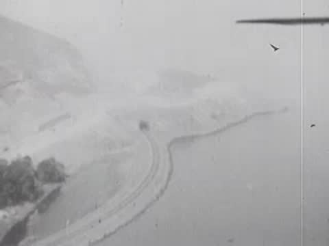 An aerial view of a coastal road and landscape.