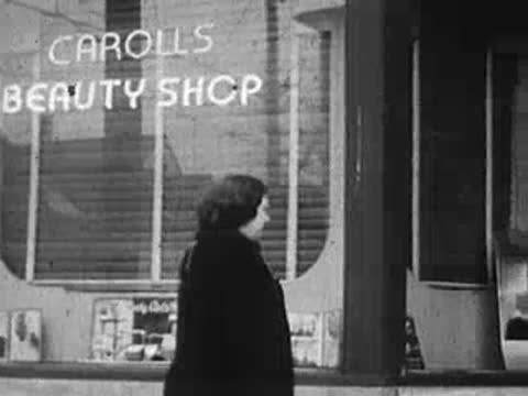 Exterior storefront view of Caroll's Beauty Shop with lettering and display window.