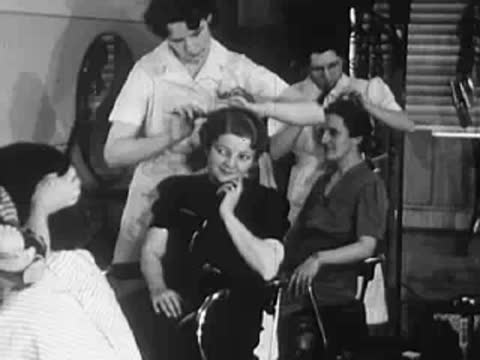 Salon interior showing stylists working on various customers.