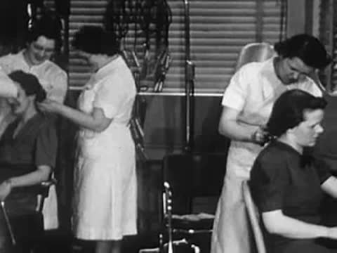 Stylist working on a customer's hair in front of a mirror.