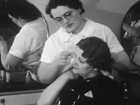 Stylist finishing a customer's styled hair with a comb.