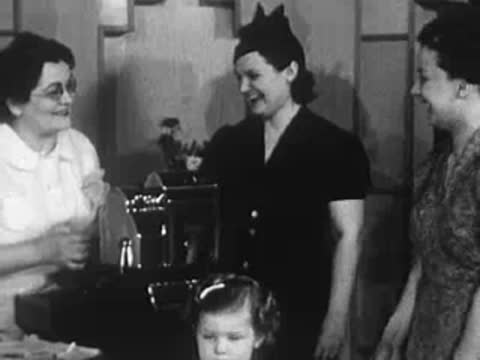 Stylist conversing with customers near the counter.