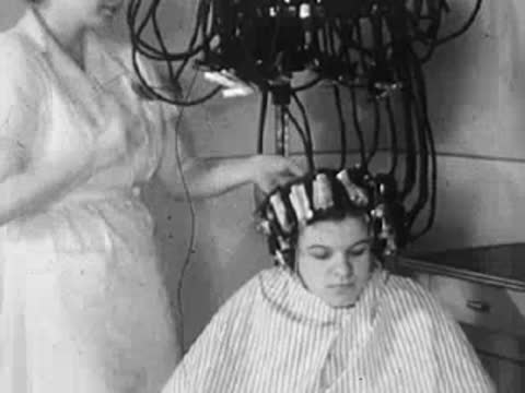 Interior view of a woman sitting under a hair dryer in the salon.