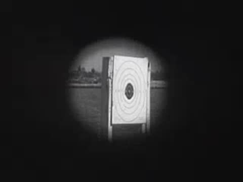 Shooting targets stand near water, transitioning to a boat on a trailer.
