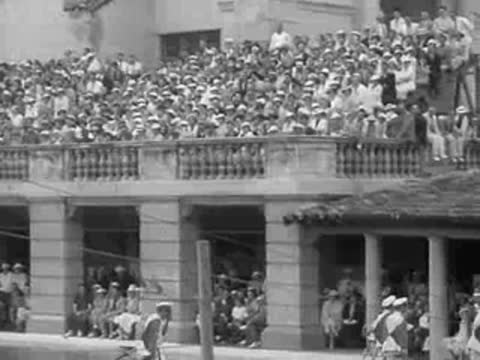 crowds watch events at a pool from balconies and arches in 1936