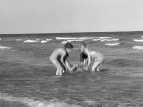 People in swimsuits splashing and playing in ocean surf
