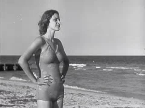 Woman standing with hands on hips in swimsuit on beach