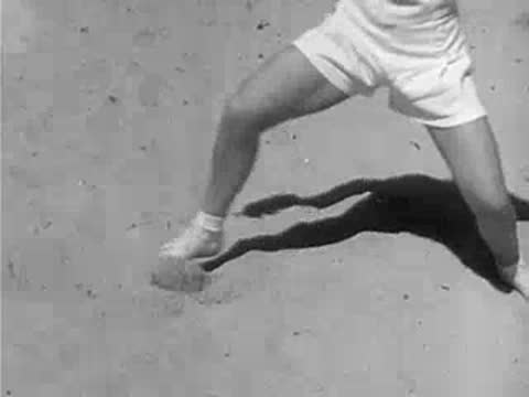 Fencers in white standing in fighting stances on sandy beach