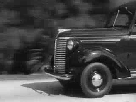 Delivery truck driving down a palm-lined road