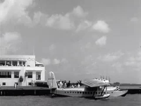 Pan American Airways seaplane docked at a terminal building by the water