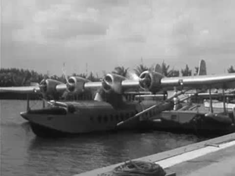 Pan American Airways four-engine seaplane docked at a waterfront terminal