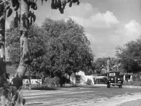 Person standing near a terminal entrance with ropes and a flag on a pole